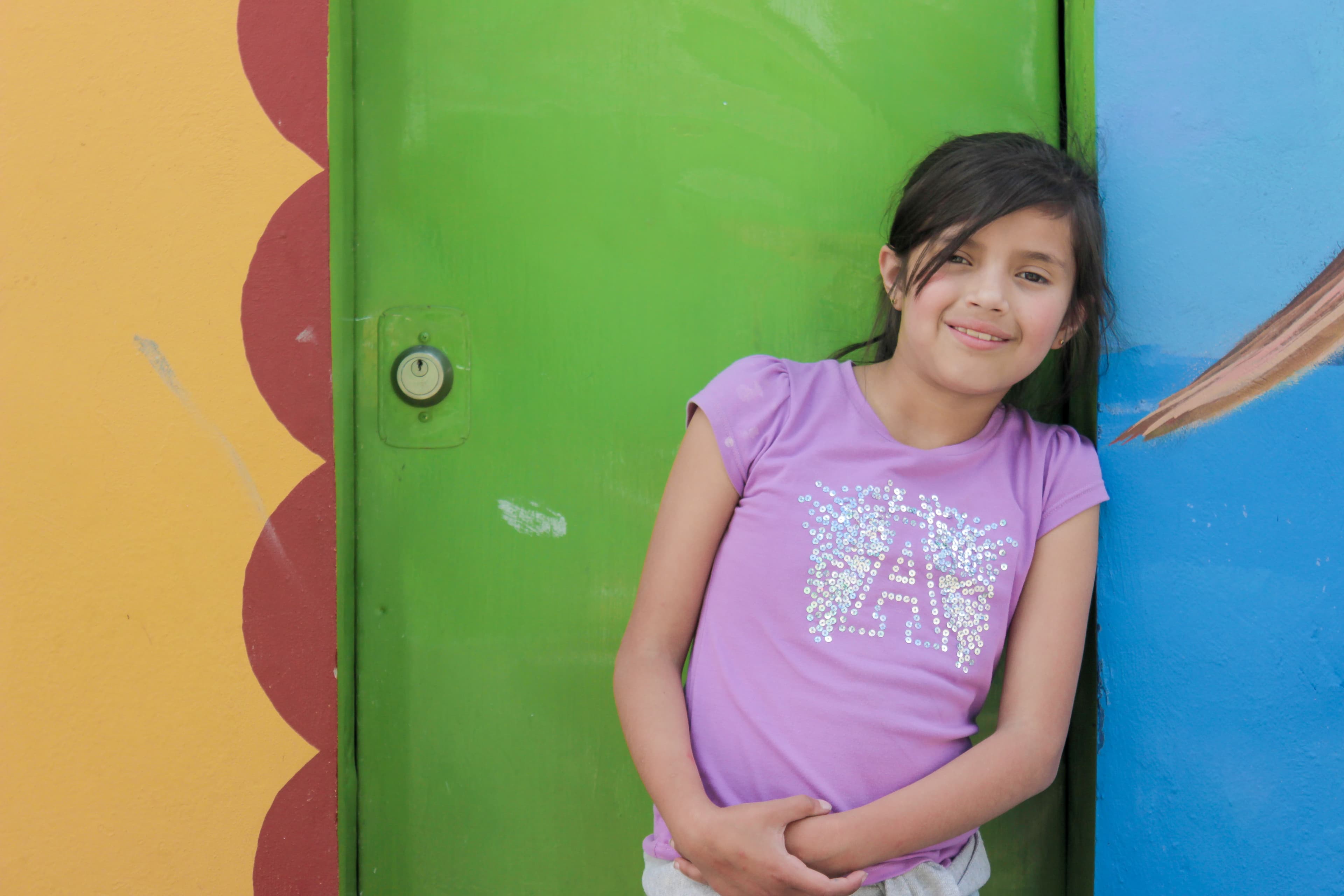 Fundación Buena Semilla — niña sonriente frente al mural de colores
